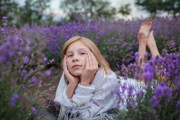 La ragazza sognante dell'adolescente giace nel campo di lavanda bellezza della natura paesaggio calmo stile di vita estivo