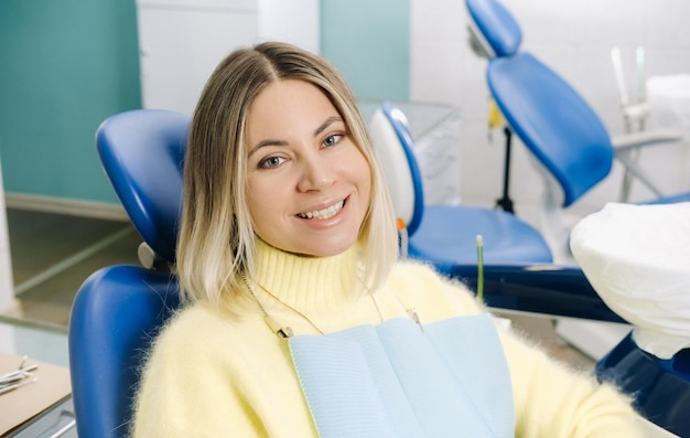 La ragazza sorride al dentista e la guarda