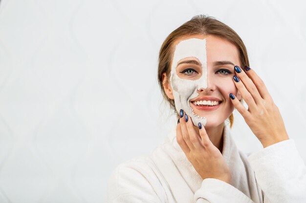 La ragazza sorridente applica la maschera facciale