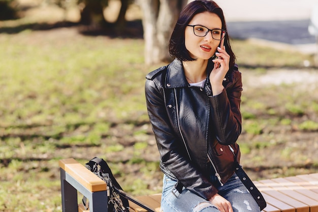 La ragazza sorridente attraente parla dal telefono