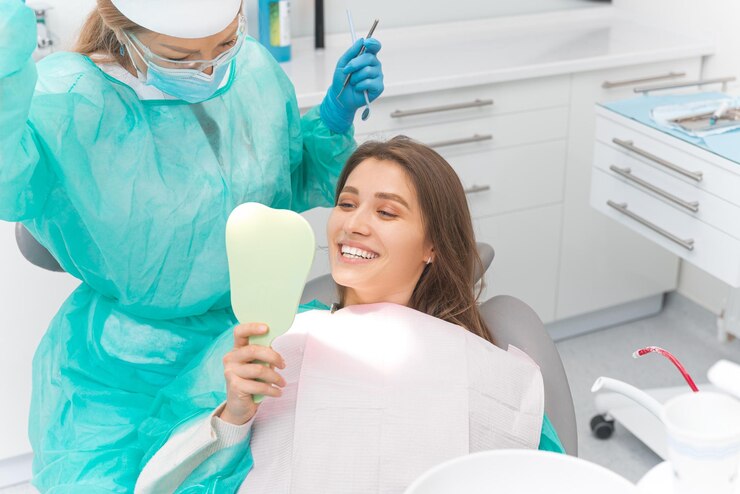 La ragazza sorridente si guarda allo specchio controllando i suoi bei denti