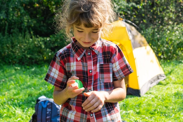 La ragazza spruzza spray antizanzare sulla pelle in natura che le morde mani e piedi Protezione dalle punture di insetti repellente sicuro per i bambini Attività ricreative all'aperto contro le allergie Ora legale