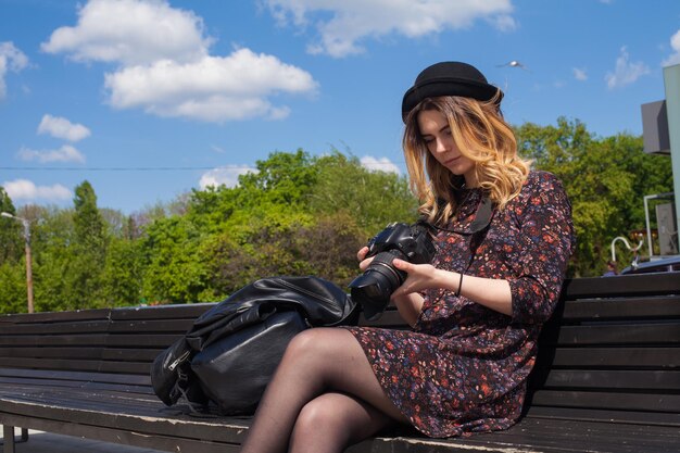 La ragazza sta controllando le foto sulla fotocamera digitale