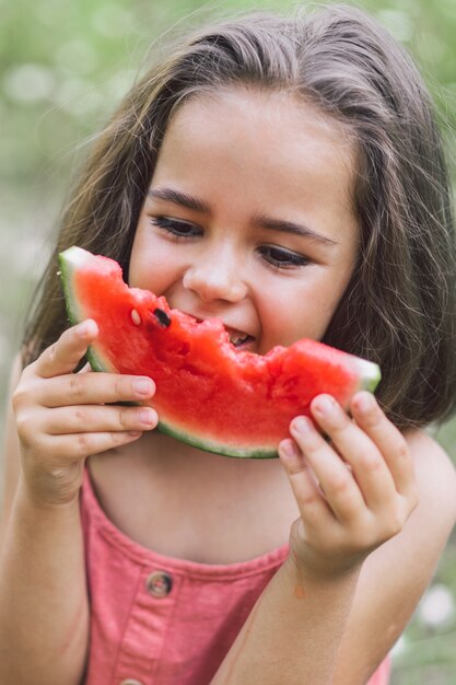 La ragazza sta mangiando un'anguria. Atmosfera estiva.