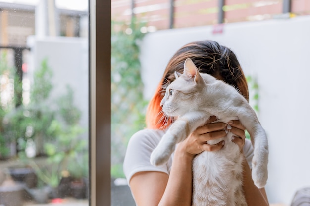 La ragazza sta portando il suo gatto è venuto a nascondere il viso.