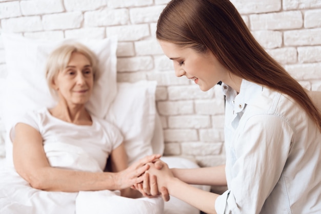 La ragazza sta preoccupandosi per la donna a letto a casa