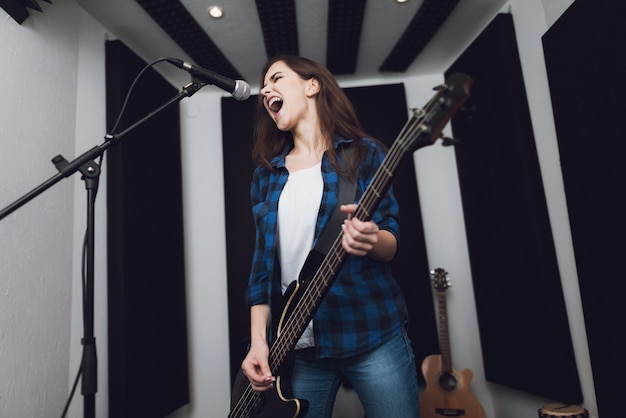 La ragazza sta registrando una canzone in un moderno studio di registrazione.