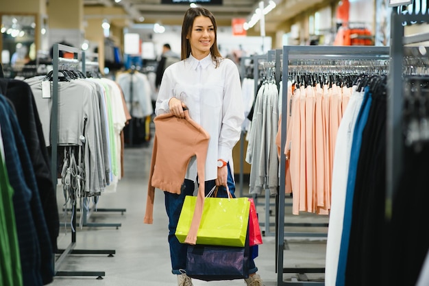 La ragazza sta scegliendo di comprare vestiti al centro commerciale