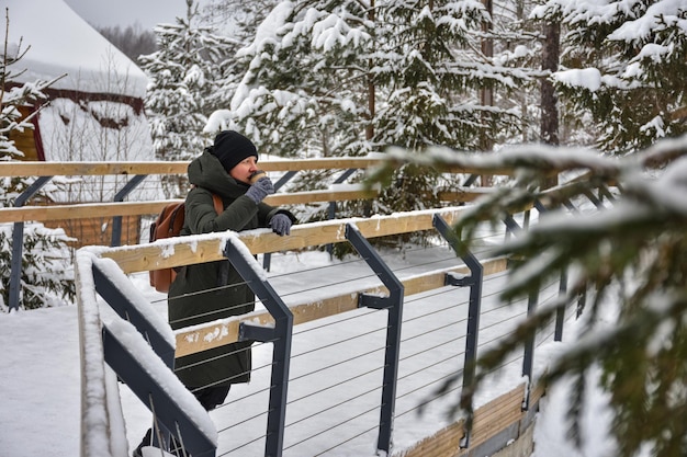 La ragazza sta sul ponte e guarda il paesaggio invernale