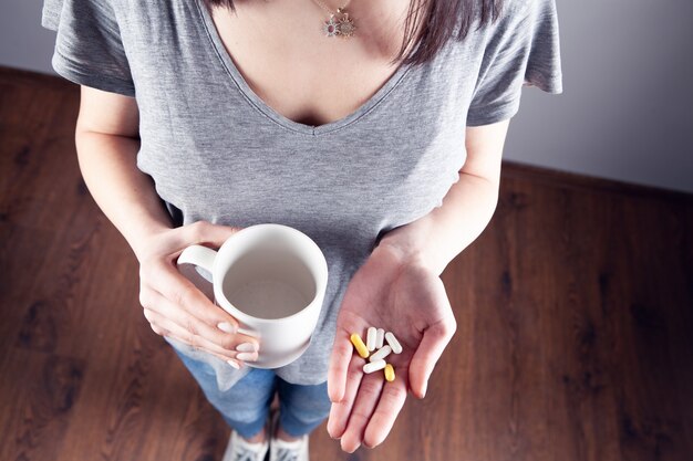 La ragazza sta tenendo una sveglia e un farmaco. vista dall'alto