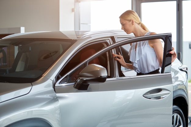 La ragazza sta valutando l'acquisto di una nuova auto in concessionaria