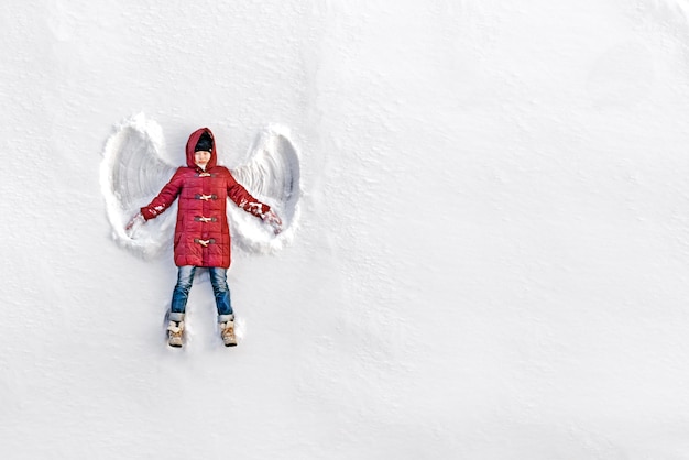 La ragazza su un angelo di neve mostra