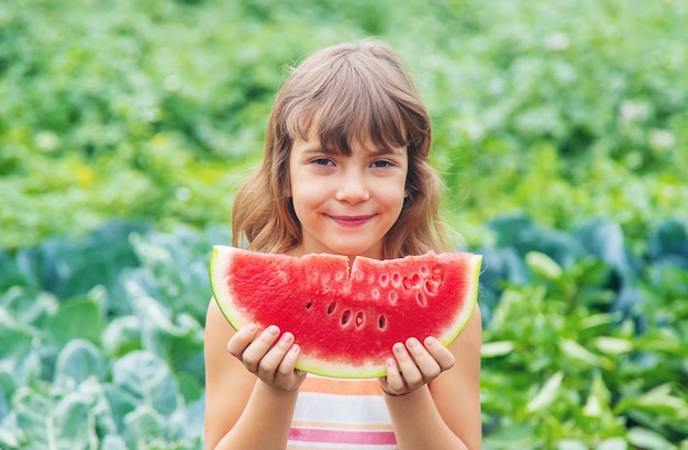 La ragazza su un picnic mangia un'anguria.