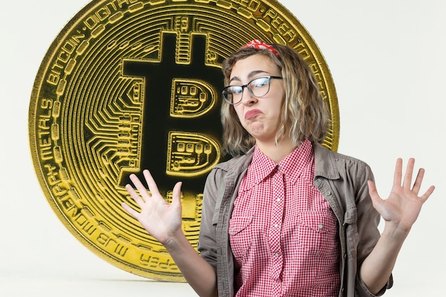 La ragazza sullo sfondo di Bitcoin Pensando alla domanda l'espressione pensierosa sembra incredula