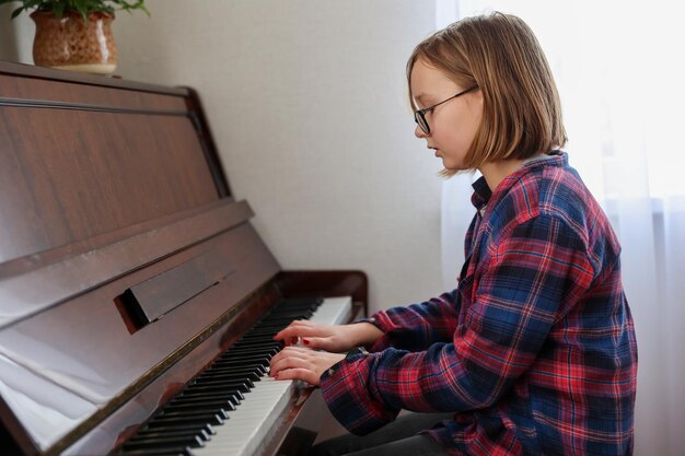 La ragazza suona il primo piano del pianoforte