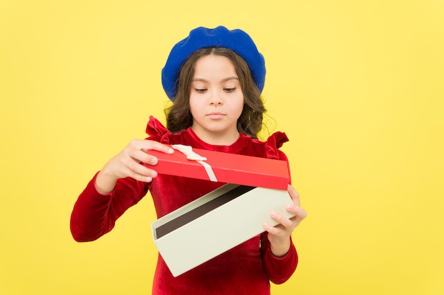 La ragazza teenager apre la casella attuale per il suo regalo di celebrazione delle vacanze di compleanno