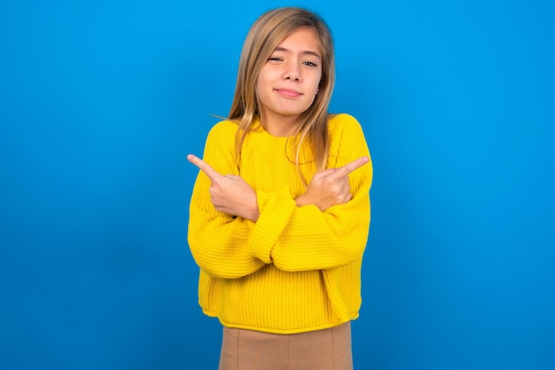 la ragazza teenager caucasica che indossa le braccia e i punti delle croci gialle su lati diversi esita.