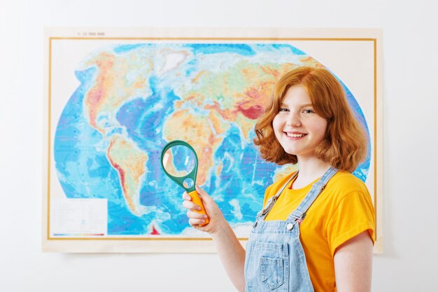 La ragazza teenager sta alla mappa geografica