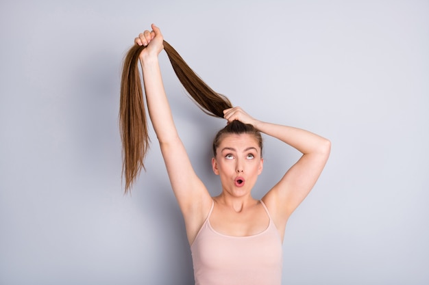 la ragazza tiene i capelli in una coda di cavallo con le mani