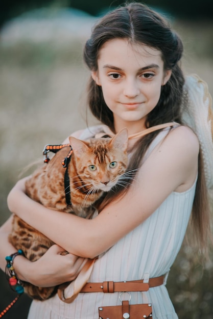 La ragazza tiene in mano un gatto rosso del Bengala