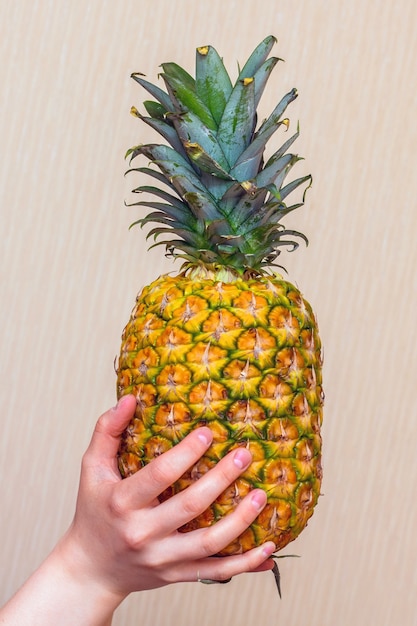 La ragazza tiene in mano un gustoso ananas maturo