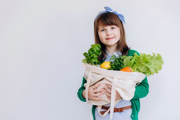 La ragazza tiene in mano una borsa ecologica con verdure Verdure Zero rifiuti senza plastica Eco concept