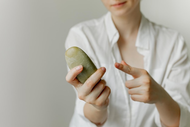 La ragazza tiene in mano una saponetta su uno sfondo bianco