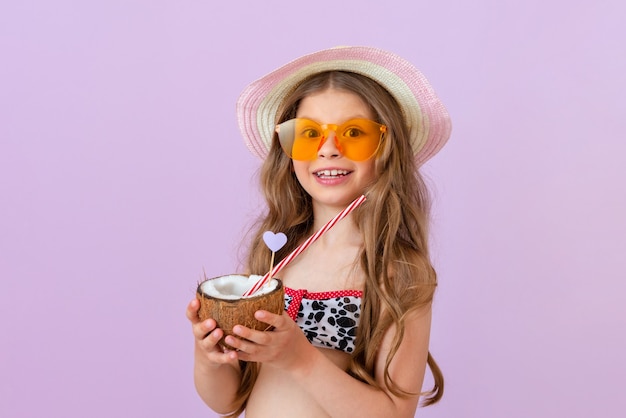 La ragazza tiene tra le mani un cocktail versato in una noce di cocco.