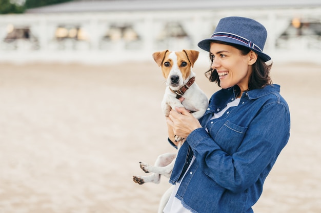 La ragazza tiene un cane tra le braccia