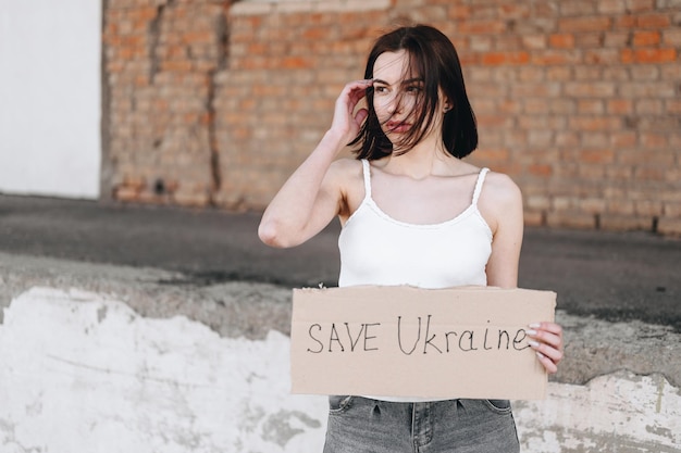 La ragazza tiene un cartello sulla richiesta di fermare la guerra Salva l'Ucraina