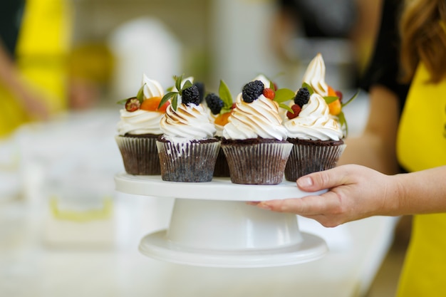 La ragazza tratta i suoi amici con i muffin dolci che ha cotto. Dolci, ricette, cucina