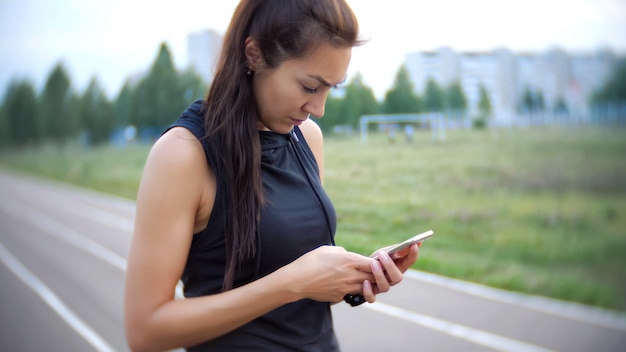 La ragazza usa l'app per lo sport e tiene il suo telefono.