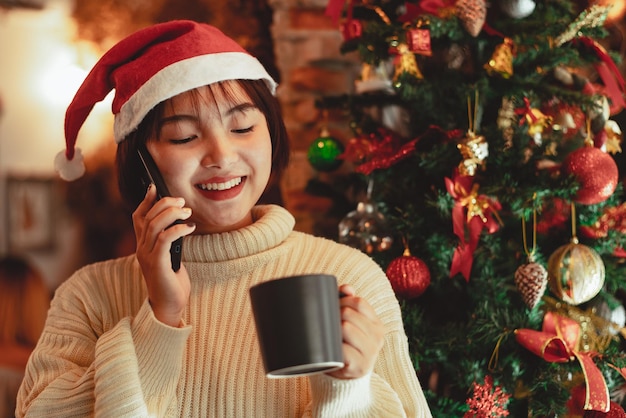 La ragazza usa lo smartphone e si gode le vacanze di Natale, il concetto di celebrazione del nuovo anno.