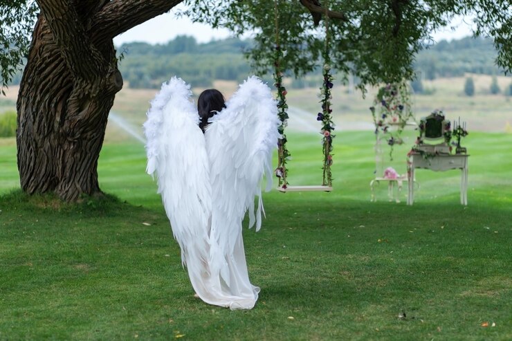 La ragazza vestita come un angelo nel giardino dell'Eden in estate