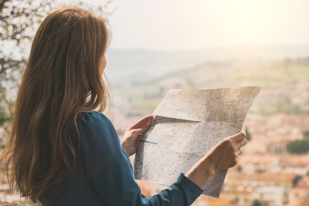 La ragazza viaggiatrice guarda la mappa delle passeggiate a Certaldo. Toscana, Italia