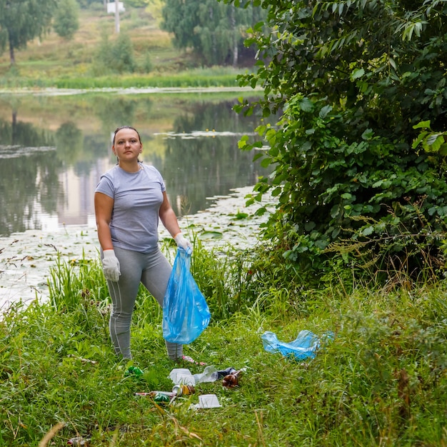 La ragazza volontaria rimuove l'immondizia da una discarica in natura.