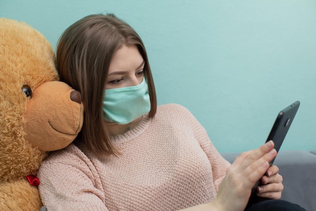 La ragazzina impara per l'esame insieme al grande orsacchiotto. Entrambi indossano una protezione.