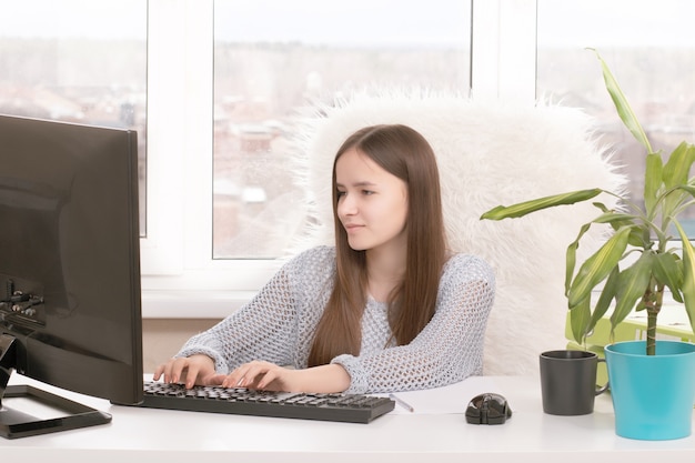 La ragioniera si siede a un tavolo, digita su un computer, sorride, scrive, lavora