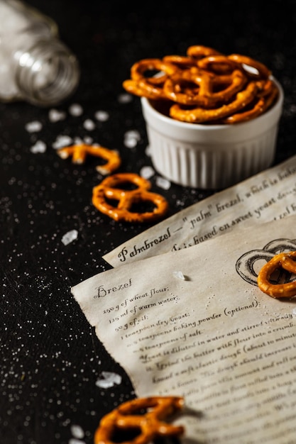 La ricetta per fare i salatini è scritta su un pezzo di carta, accanto ad essa si trovano sale e salatini.