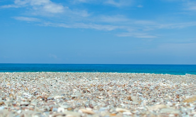 La riva del mare con pietre e il cielo blu