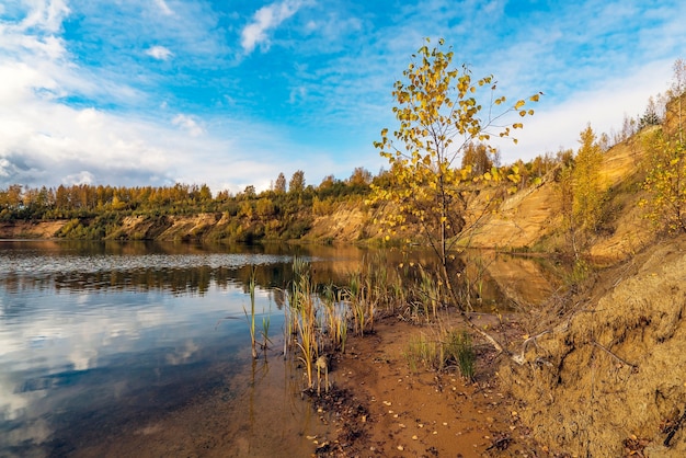 La riva sabbiosa di un lago di montagna in autunno .regione di Leningrado.