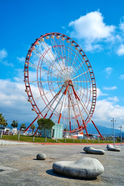 La ruota panoramica è rossa e bianca contro il cielo.