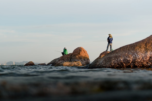 La sagoma del pescatore sulla roccia al mare