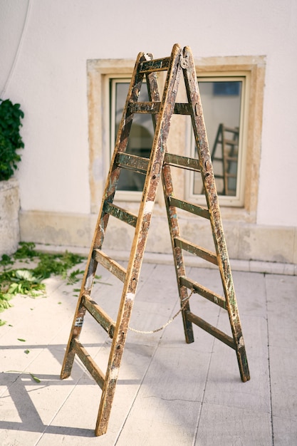 La scala in legno si erge su una piastrella nel cortile della casa
