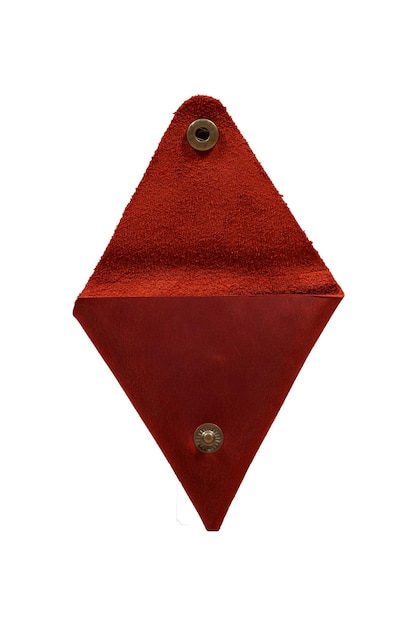 La scatola di monete in pelle autentica triangolare rossa fatta in casa con ferramenta in bronzo isolata su sfondo bianco è aperta
