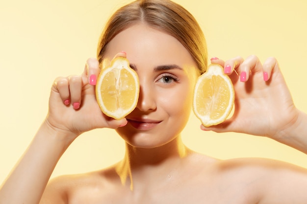 La scelta dell'eco. Primo piano di un bel viso femminile con fettine di limone