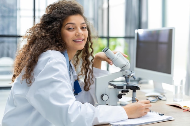 La scienziata in cappotto di medicina lavora in un laboratorio scientifico