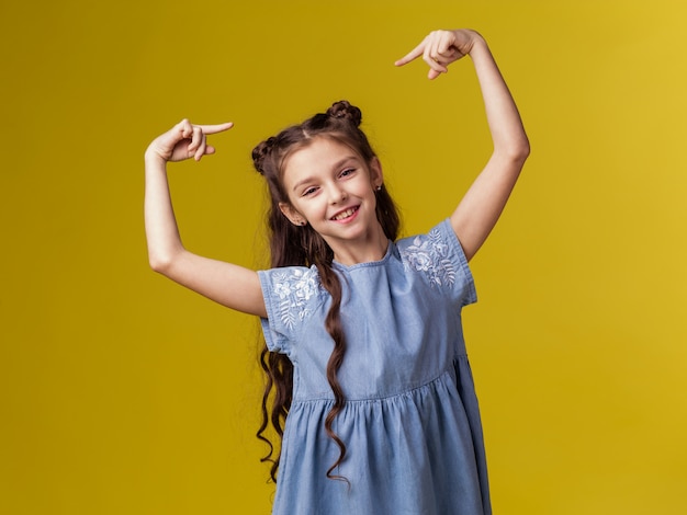 La scolara del bambino della ragazza con capelli lunghi indica la sua testa