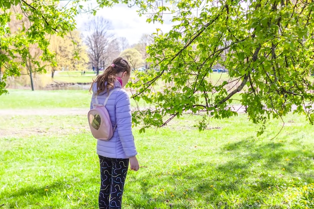 La scolaretta cammina nel parco primaverile