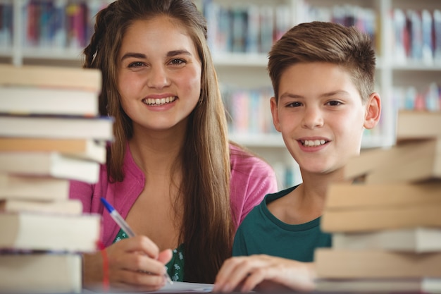 La scuola sorridente scherza fare i compiti in biblioteca a scuola